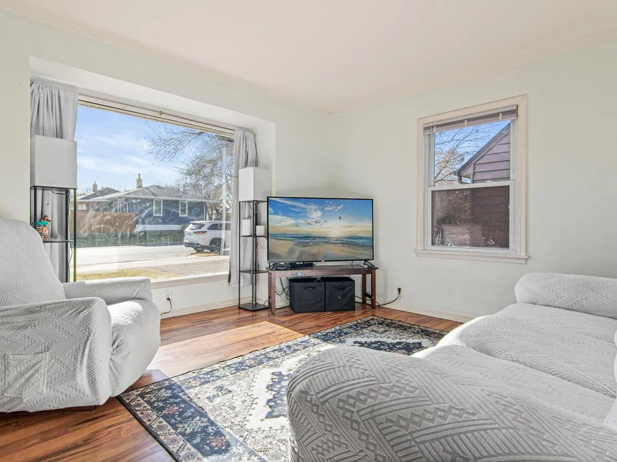 Bright, neutral living room staged with light furniture and clean wood floors