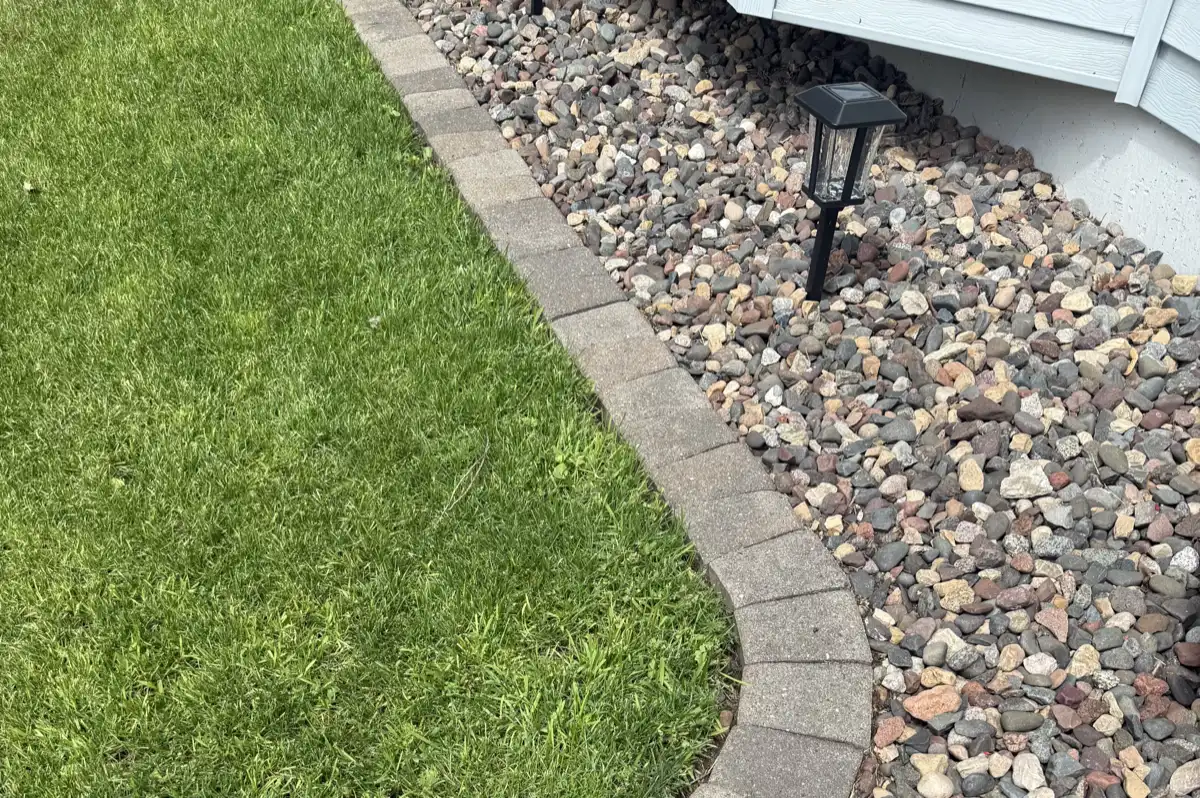 A clean mulch and rock border edged against a mown lawn