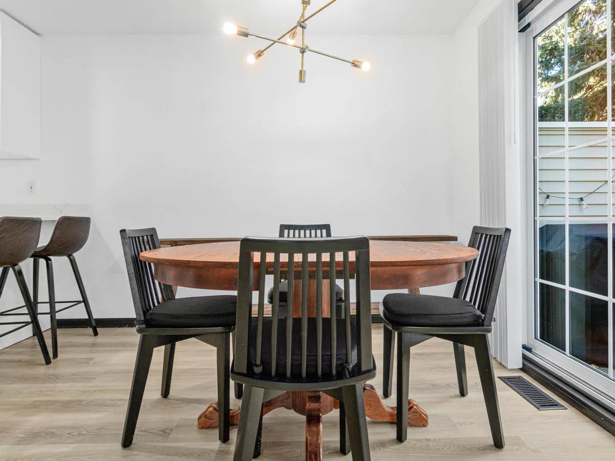 Simple staged dining nook with neutral walls and an updated light fixture